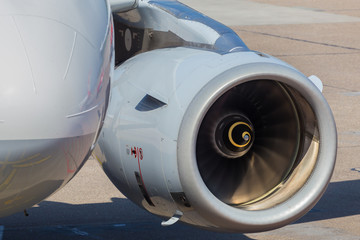 Fototapeta premium An up-close aircraft turbine photographing with part of the wing during the day in sunshine.