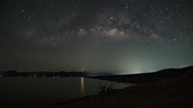 4K Timelapse day to night , the Milky Way and faded away when the sun rises. At Khlong Din Daeng Reservoir.