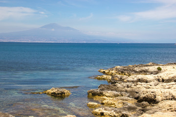 Brucoli scenic view of rocky coast, blue sea and far mount Etna