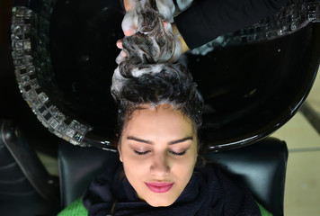 young woman in hairdresser salon washing hair