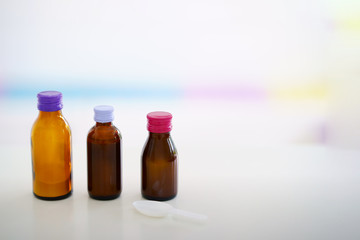 Glass drug bottles with colorful caps on blur background