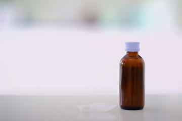 Glass drug bottles with white caps on blur background with copy space