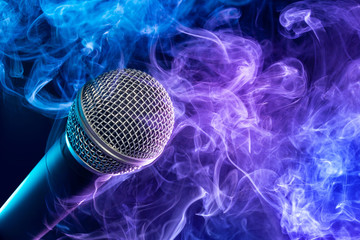 closeup of microphone enveloped in a purple-bluish puff of smoke