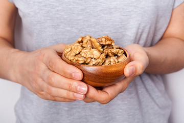 Woman's in hand walnut in a bowls. Healthy food and snack.