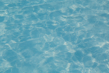 Blue pool water with sun reflections