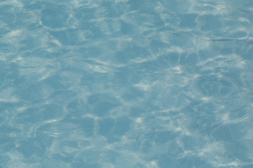 Blue pool water with sun reflections