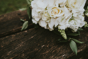 wedding rings on a bouquet of white roses