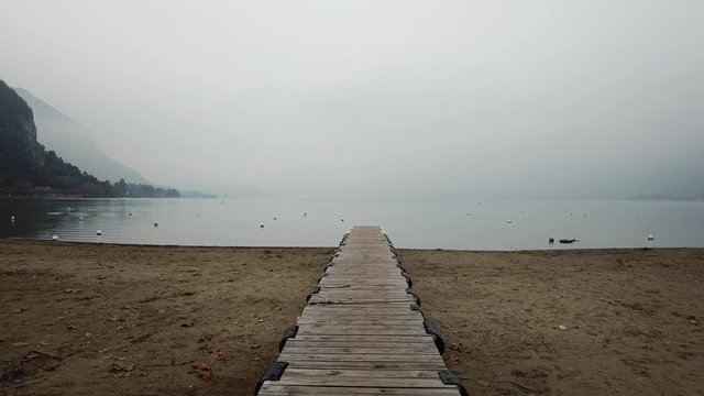 empty pier in foggy cloudy day, scenic nature, wooden jetty on the lake