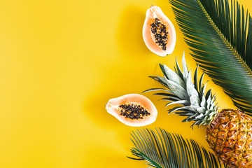 Summer composition. Tropical palm leaves, hat, fruits on yellow background. Summer concept. Flat lay, top view, copy space