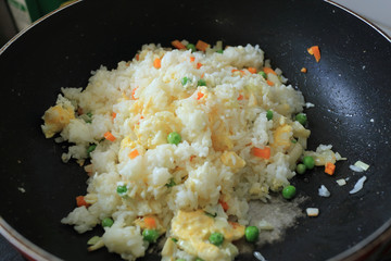 Fried rice cooking in hot iron pan. Asian food ingredient.