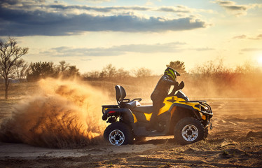 Racing powerful quad bike on the difficult sand in the summer. © Bondariev Volodymyr.