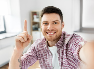 blogging, videoblog and people concept - man or blogger videoblogging or taking selfie and pointing...