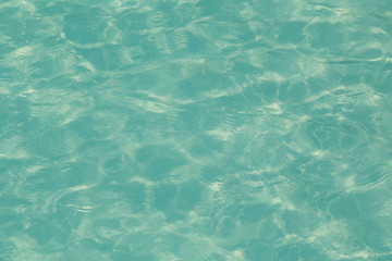 Blue pool water with sun reflections