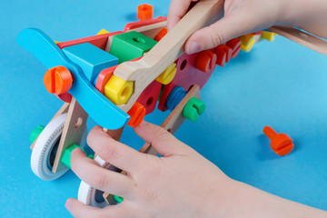child playing with constructor and make a plain, closeup