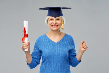 graduation, education and old people concept - happy senior graduate student woman in mortar board...