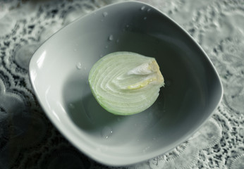 Sliced onion on a plate. Cooking with onions. Onion cut in half