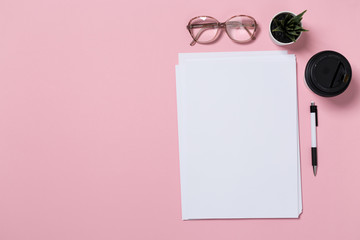 top view of a open notebook on a pink background.