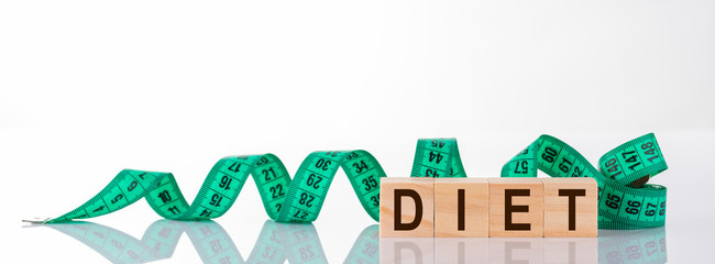 DIET word written on wooden block cubes isolated on white background. turquoise metric measuring...