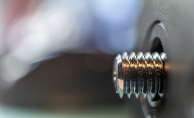 Macro image of a horizontal screw with shallow depth of field and intentionally blurred background