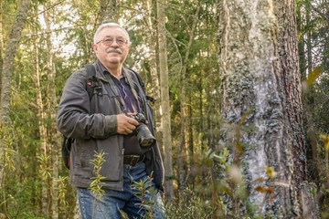 Obraz premium Walking with a camera in the spring forest. The photographer examines the surroundings in search of interesting subjects.