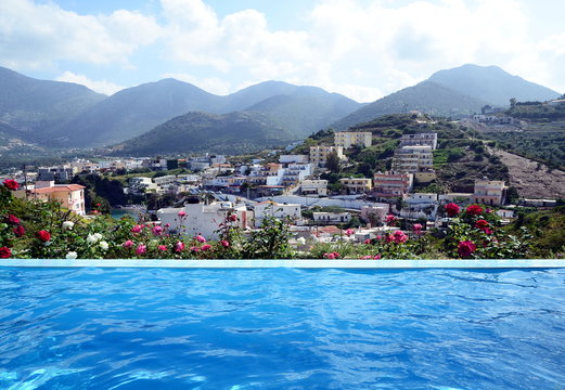 Luxury infinity swimming pool and blue water at a private huge villa with beautiful sea and mountain view. Bali district at Crete island, Greece.