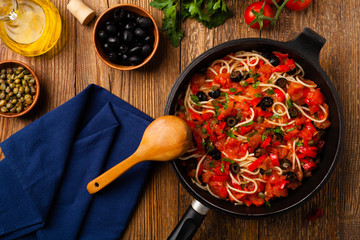 Italian spaghetti alla Pultanesca with tomatoes and olives. Served without meat and cheese.