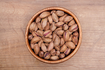 Pistachio  in a bowls on wooden table. Healthy food and snack.
