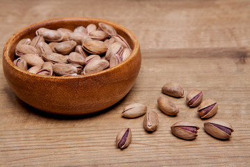 Pistachio  in a bowls on wooden table. Healthy food and snack.