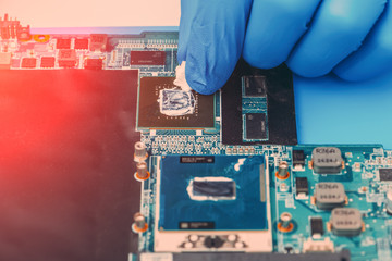 Application of thermal paste on the laptop processor chip for high-quality cooling.