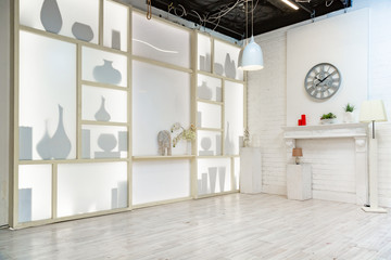 modern white studio. with a light stand in the middle, with a special light on the back wall.