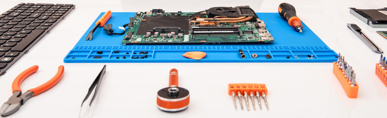 The repairman works in technical support, is engaged in the restoration and cleaning of the laptop.