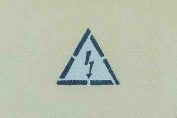 High voltage warning sign on a light yellow metal wall