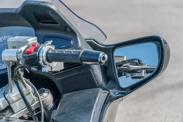 Beautiful and stylish control panel and steering wheel of a modern motorcycle at close range against the background of the city.