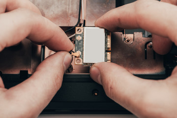 Engineer dismantles the details of a broken laptop for repair