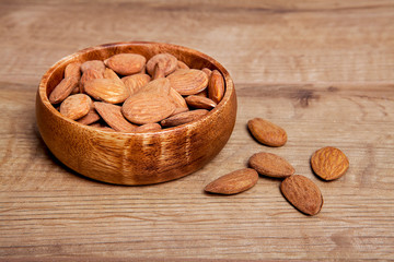 Almond in a bowls on wooden table. Healthy food and snack.