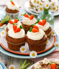 Carrot cupcakes with mascarpone cream decorated with marzipan carrots on a plate. Delicious homemade dessert