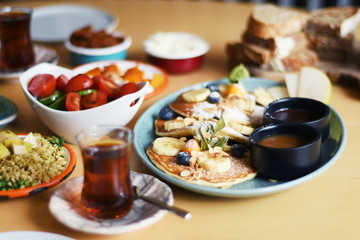 Delicious breakfast with pancakes and tea on a table