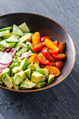 Vegan buddha bowl. Healthy vegetarian salad with cherry tomatoes, cucumber, radish,, avocado and lettuce.