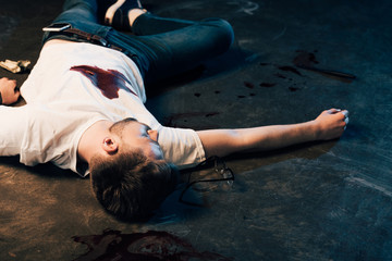 Fototapeta na wymiar dead man with smartphone in pocket on floor at crime scene