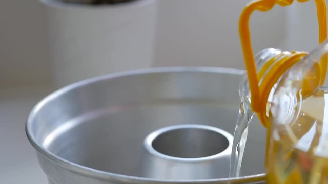 Close-up Of Pouring Cooking Oil Into A Bundt Cake Pan