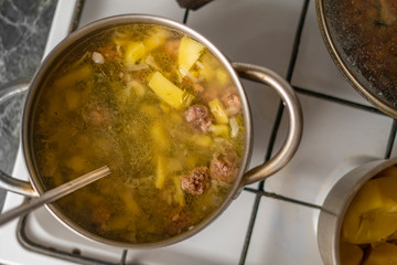 top view of boiling hot steaming soup with vegetables and meat, food preparation before a dinners