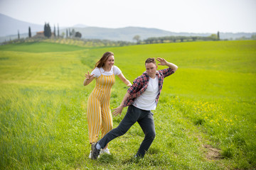 Naklejka premium A young funny couple standing on a green meadow