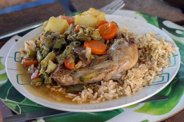 Chicken curry with rice and vegetable served on a plate