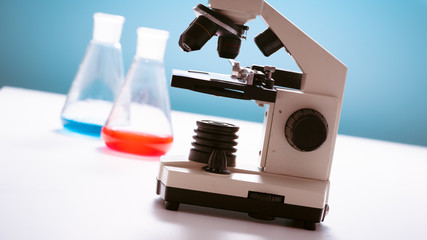 scientific experiment in school class. Microscope and test tubes on the table