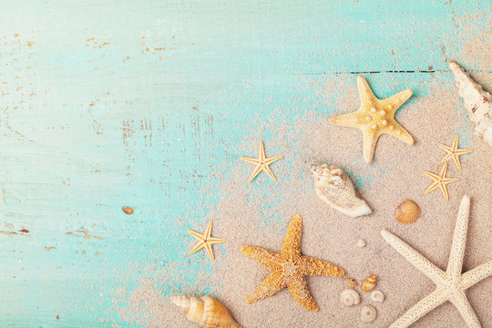 Starfishes and seashells on sand for summer holidays and travel background.