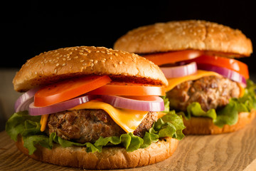 Home made hamburger with beef, onion, tomato, lettuce and cheese. Fresh burger close up on wooden...