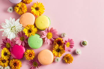 Still life and food photo of cake macarons in a gift box with flowers, a cup of tea on light background. Sweets and desserts concept of macaroons.