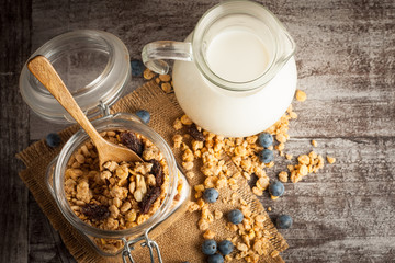 Healthy breakfast concept with oat flakes and fresh berries on rustic background. Food made of granola and muesli. Healthy banana smoothie with blackberries, honey and milk.