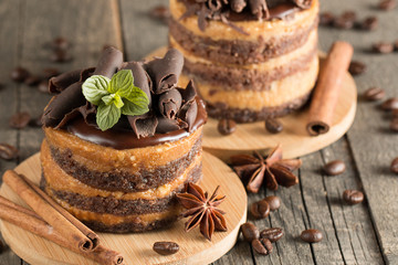Dark chocolate cakes on black slattern board with mint, cinnamon, coffee beans on a wooden  background. Tasty dessert food concept.