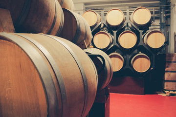 Wooden barrels with whiskey in dark cellar. Modern production of whiskey with the observance of age-old traditions.